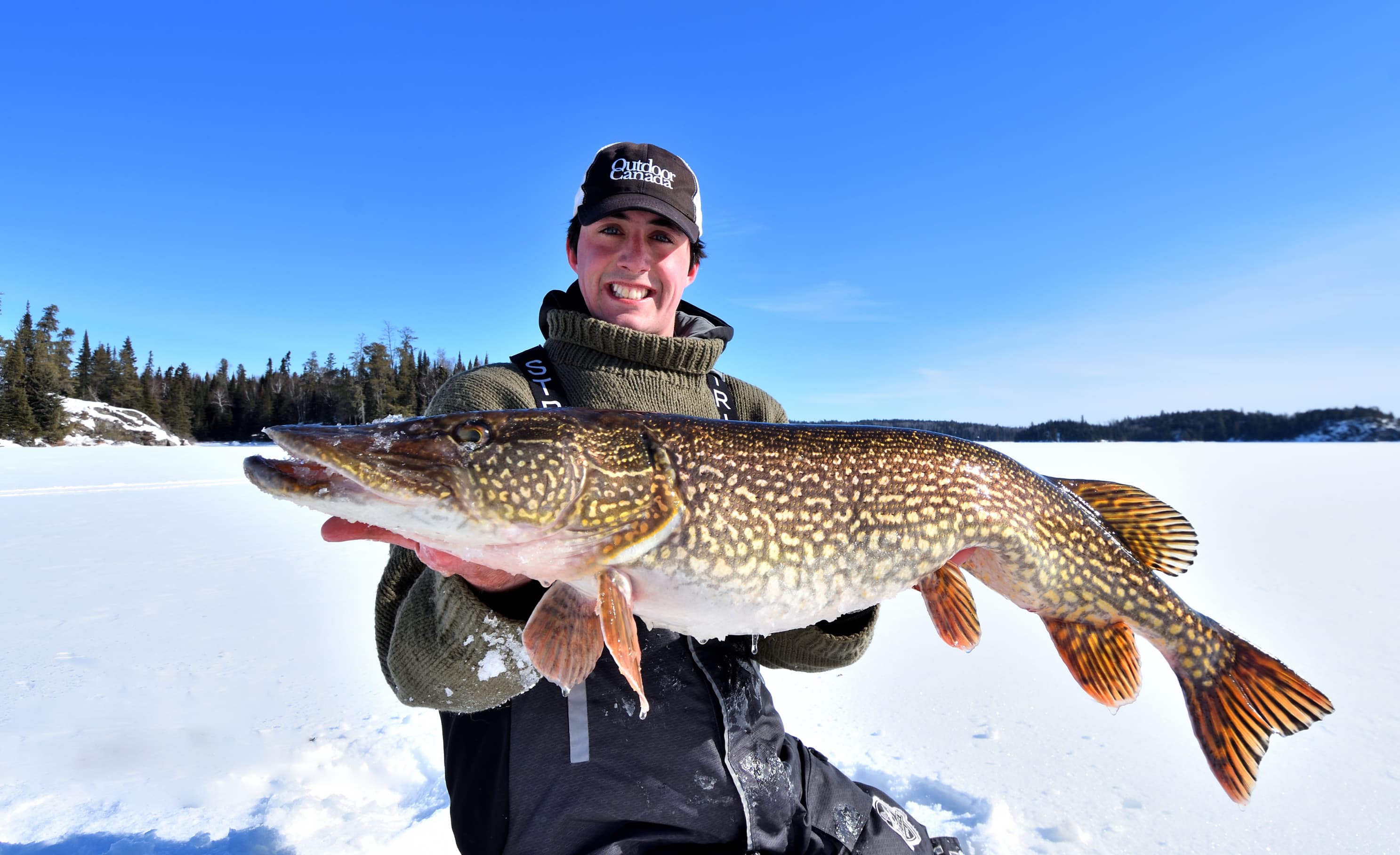 A happy customer holding a large pike caught on Lake Simcoe.