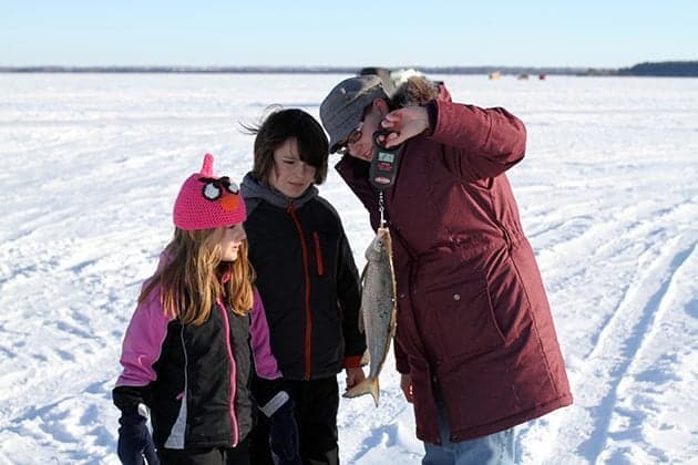 A family enjoying a day of ice fishing in a Biggie shack.